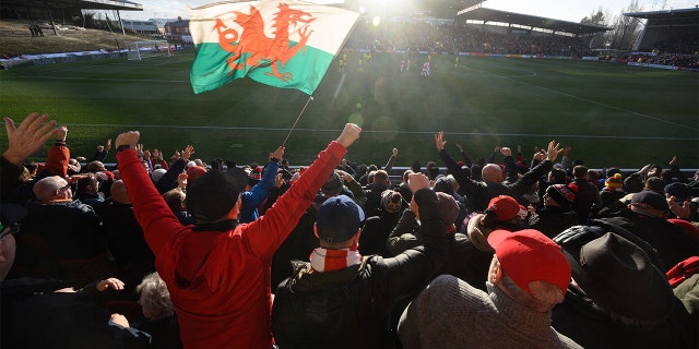 Supporters celebrate Wrexham Association Football Club's first goal during a National League fixture football match against Maidenhead United, at the Racecourse Ground stadium, in Wrexham, north Wales, on January 29, 2022.