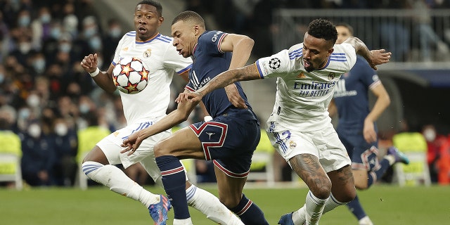 كيليان مبابي ، وسط ، من باريس سان جيرمان ، في مواجهة إيدر ميليتاو ، يمينًا ، من ريال مدريد ، خلال دور الستة عشر لدوري أبطال أوروبا ، لعب مباراتين في 9 مارس 2022 في مدريد ، إسبانيا.