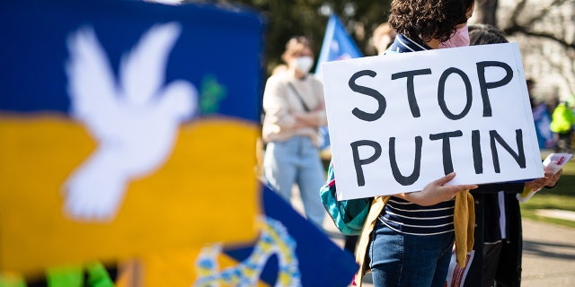 During a demonstration in the upper castle garden against Russia's military deployment in Ukraine, a woman holds a sign with the inscription ""Stop Putin"" in her hand on March 13, 2022. 