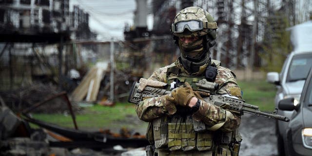 A Russian soldier stands guard at the Luhansk Power Plant in the town of Shchastya April 13, 2022. 