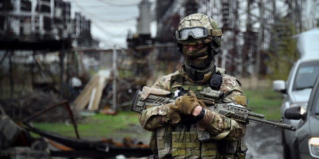 In this picture taken on April 13, 2022, a Russian soldier stands guard at the Luhansk power plant in the town of Shchastya.