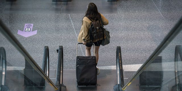 This file image shows a female traveler at Logan International Airport in Boston, Massachusetts, on Thursday, April 21, 2022.