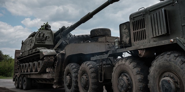This photograph, taken on May 10, 2022, shows a Ukrainian army self-propelled howitzer loading onto a tank transporter near Bakhmut in eastern Ukraine during the Russian invasion of Ukraine.