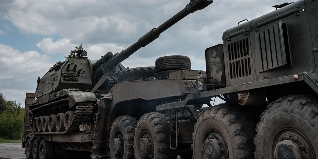 This photograph, taken on May 10, 2022, shows a Ukrainian army self-propelled howitzer loading onto a tank transporter near Bakhmut in eastern Ukraine during the Russian invasion of Ukraine.