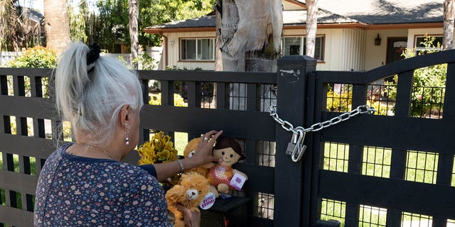 Sandra DeLatorrre leaves a candle and toys in front of the home in the 22500 block of Victory Boulevard Wednesday, May 11, 2022.