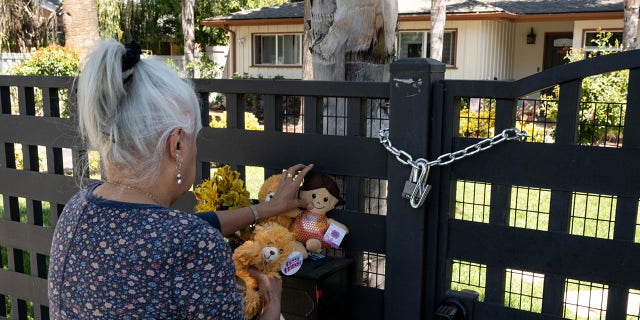 Sandra DeLatorrre leaves a candle and toys in front of the home in the 22500 block of Victory Boulevard Wednesday, May 11, 2022.