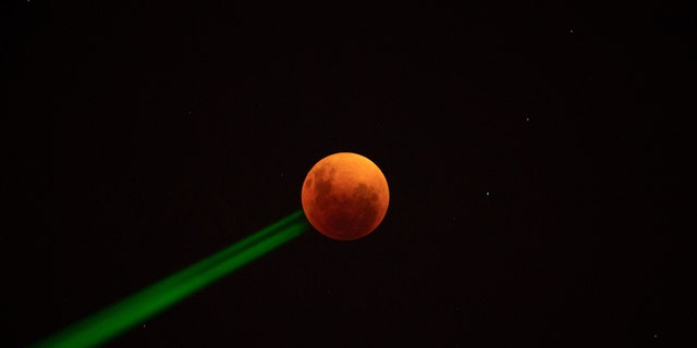 The blood moon is seen during a total lunar eclipse in Santiago, on May 15, 2022. (Photo by MARTIN BERNETTI / AFP) (Photo by MARTIN BERNETTI/AFP via Getty Images)