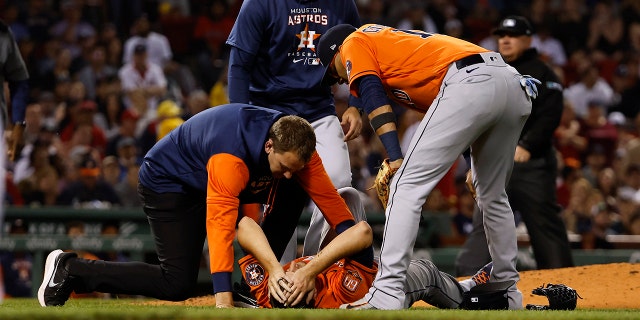 A trainer talks to Houston Astros pitcher Jake Odorizzi during the Red Sox game at Fenway Park, May 16, 2022, in Boston, Massachusetts.