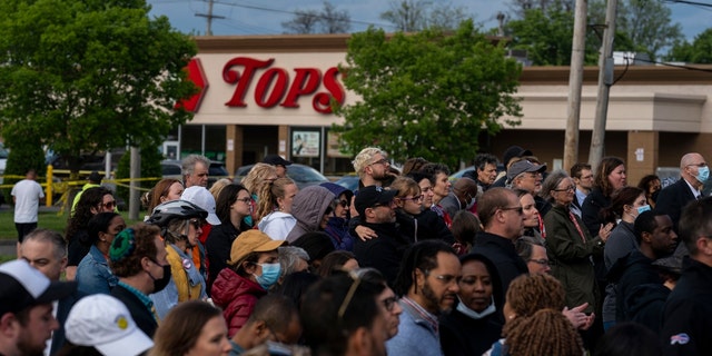 People attend a vigil across the street from Tops Friendly Market at Jefferson Avenue and Riley Street on Tuesday, May 17, 2022 in Buffalo, NY.