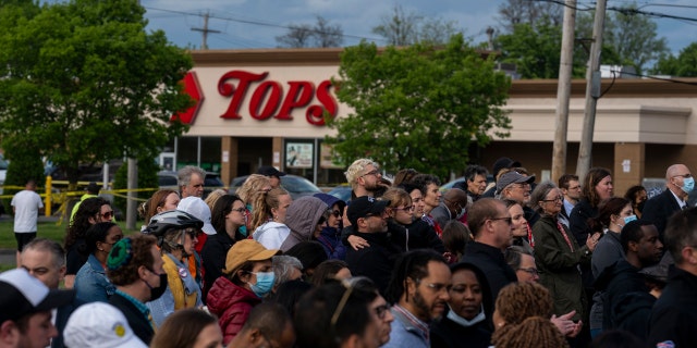 People attend a vigil across the street from Tops Friendly Market at Jefferson Avenue and Riley Street on Tuesday, May 17, 2022 in Buffalo, NY.