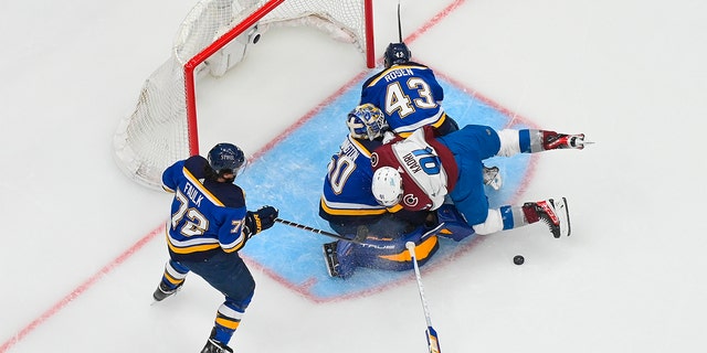 Nazem Kadri (91) of the Colorado Avalanche collides with Jordan Binnington (50) and Calle Rosen (43) of the St. Louis Blues in Game 3 of the second round of the 2022 Stanley Cup Playoffs at the Enterprise Center May 21, 2022, en St. Luis.