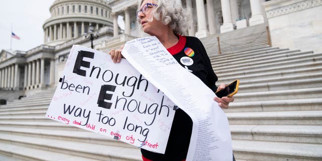 Cindy Nell of Prince Georges County, Md., holds a list of school shootings since 1998 during a demonstration with Moms Demand Action for Gun Sense in America on Wednesday, May 25, 2022, at the Senate steps of the U.S. Capitol after the latest mass shooting at a Texas elementary school.