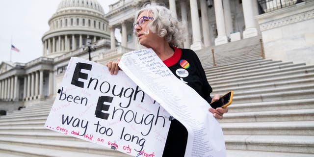 Cindy Nell of Prince Georges County, Md., holds a list of school shootings since 1998 during a demonstration with Moms Demand Action for Gun Sense in America on Wednesday, May 25, 2022, at the Senate steps of the US Capitol after the latest mass shooting at a Texas elementary school.