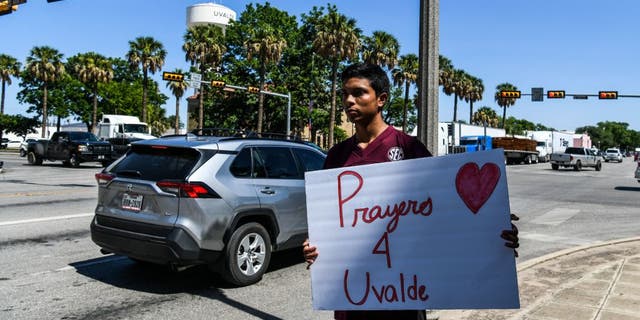 A local resident holds a placard that reads "Prayers 4 Uvalde" after the mass shooting at Robb Elementary School in Uvalde, Texas, on May 25, 2022.