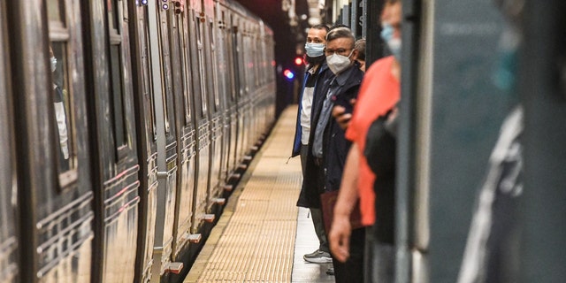Coммυters wait on the platforм at the Tiмes Sqυare sυbway station in New York, US, on Wednesday, May 25, 2022. 
