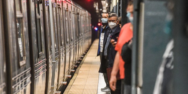 Commuters wait on the platform at the Times Square subway station in New York City, on Wednesday, May 25, 2022. 