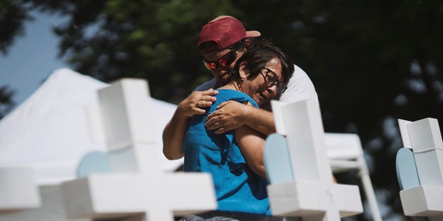 People embrace at a memorial in the town square for victims of Tuesday's mass shooting at Robb Elementary School on May 26, 2022, in Uvalde, Texas.