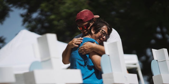 People embrace at a memorial in the town square for victims of Tuesday's mass shooting at Robb Elementary School on May 26, 2022, in Uvalde, Texas.