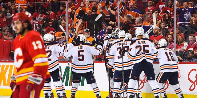 The Edmonton Oilers celebrate after defeating the Calgary Flames during the overtime period of Game Five of the Second Round of the 2022 Stanley Cup Playoffs at Scotiabank Saddledome on May 26, 2022, in Calgary, Alberta, Canada. The Flames defeated the Oilers 5-4 in overtime.