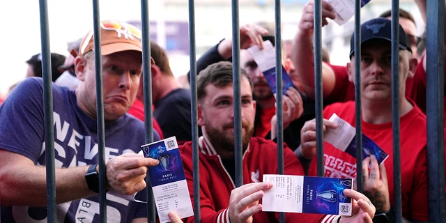Liverpool fans stuck outside the ground show their match tickets during the UEFA Champions League Final at the Stade de France, Paris. Picture date: Saturday May 28, 2022.