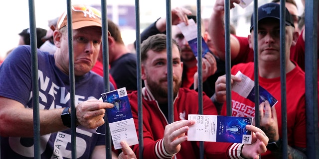Liverpool fans stuck outside the ground show their match tickets during the UEFA Champions League Final at the Stade de France, Paris. Picture date: Saturday May 28, 2022.