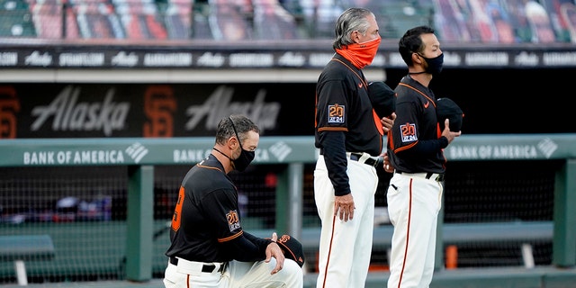 Manager Gabe Kapler, 对, of the San Francisco Giants, kneels during the playing of the National Anthem prior to a game against the Texas Rangers at Oracle Park Aug. 1, 2020, in San Francisco. 