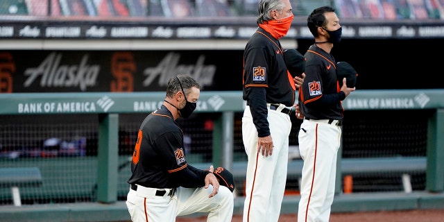Manager Gabe Kapler, right, of the San Francisco Giants, kneels during the playing of the National Anthem prior to a game against the Texas Rangers at Oracle Park Aug. 1, 2020, in San Francisco.