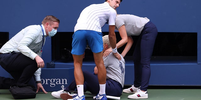 Novak Djokovic of Serbia tends to a line judge, Laura Clark, after inadvertently striking her with a ball hit in frustration during the U.S. Open on Sept. 6, 2020, in New York.