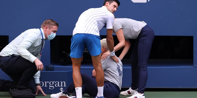 Novak Djokovic of Serbia tends to a line judge, Laura Clark, after inadvertently striking her with a ball hit in frustration during the U.S. Open on Sept. 6, 2020, in New York.