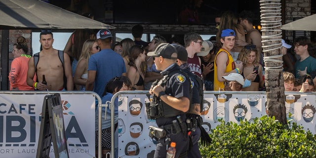 Fort Lauderdale police officers walk past Cafe Ibiza in Fort Lauderdale, Fla., March 4, 2021.
