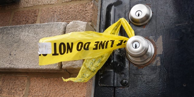 CHICAGO, ILLINOIS - MARCH 14: Crime scene tape hangs from a door knob outside of a tow company garage following a shooting where at least 15 people were reported to have been shot, two fatally, on March 14, 2021 in Chicago, Illinois.