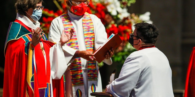 SAN FRANCISCO, CA - SEPT. 11: Elizabeth Eaton, presiding bishop of the Evangelical Lutheran Church in America, left, delivers words to Rev. Dr. Megan Rohrer, right, (they/them) as they become the first openly transgender bishop of the Evangelical Lutheran Church in America after they were installed to the Sierra Pacific Synod at Grace Cathedral on Saturday, September 11, 2021, in San Francisco, Calif. (Yalonda M. James/The San Francisco Chronicle via Getty Images)