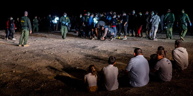 A migrant family sits after being processed on May 5, 2022, in Roma, Texas. 