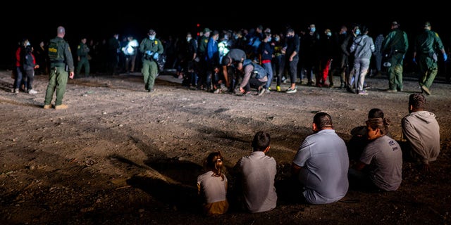 A migrant family sits after being processed on May 05, 2022 in Roma, Texas.