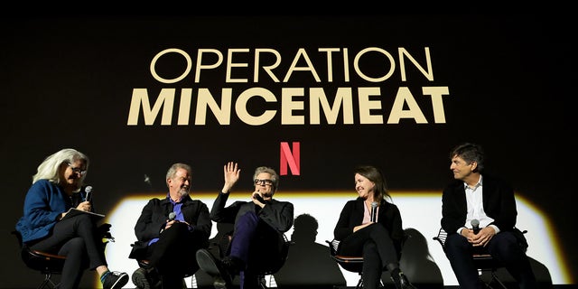 (L-R) Thelma Adams, John Madden, Colin Firth, Michelle Ashford, and Thomas Newman speak onstage during Netflix's "Operation Mincemeat" special screening in Paris in May.