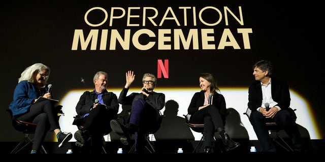 (L-R) Thelma Adams, John Madden, Colin Firth, Michelle Ashford, and Thomas Newman speak onstage during Netflix's "Operation Mincemeat" special screening in Paris in May.