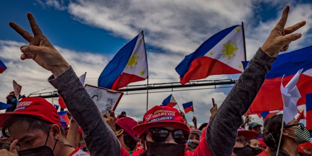 A supporter flashes the peace sign, the campaign symbol of Ferdinand Marcos Jr., during his last campaign rally before the election on May 7, 2022 in Paranaque, Metro Manila, Philippines. (Ezra Acayan/Getty Images)