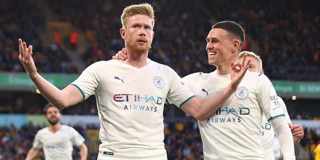 Kevin De Bruyne of Manchester City celebrates scoring his team's third goal with teammate Phil Foden during a Premier League match between the Wolverhampton Wanderers and Manchester City at Molineux May 11, 2022, in Wolverhampton, Inglaterra. 
