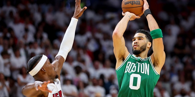 Jayson Tatum (0) of the Boston Celtics shoots over Jimmy Butler (22) of the Miami Heat during the fourth quarter in Game 1 of the 2022 NBA Eastern Conference finals at FTX Arena May 17, 2022, in Miami, Fla. 