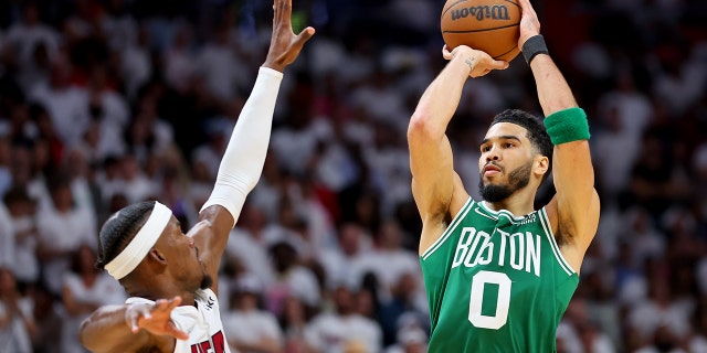 Jayson Tatum (0) of the Boston Celtics shoots over Jimmy Butler (22) of the Miami Heat during the fourth quarter in Game 1 of the 2022 NBA Eastern Conference finals at FTX Arena May 17, 2022, in Miami, Fla.