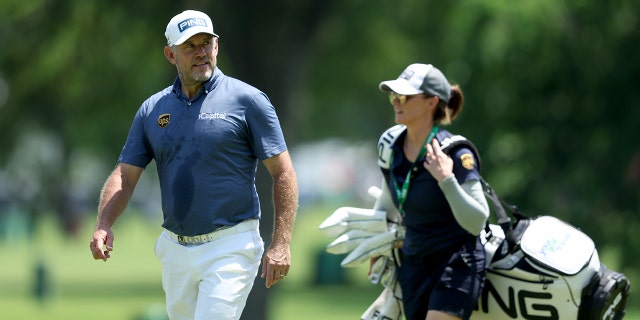 Lee Westwood of England and caddie Helen Storey walk during a practice round prior to the start of the 2022 PGA Championship at Southern Hills Country Club May 18, 2022, in Tulsa, Oklahoma.
