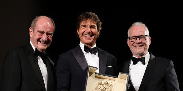 Pierre Lescure and Cannes Film Festival director Thierry Fremaux pose on stage with Tom Cruise (C) as he receives coveted award.