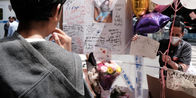 A young boy stands beside a growing memorial during a rally for an 11-year-old girl in the South Bronx who was caught in gun crossfire on Monday and killed on May 18, 2022 in New York City. 