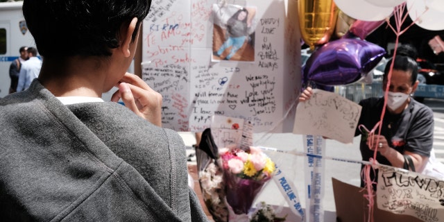 A young boy stands beside a growing memorial during a rally for an 11-year-old girl in the South Bronx who was caught in gun crossfire on Monday and killed on May 18, 2022 in New York City.