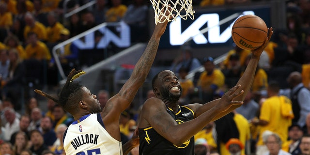 Draymond Green, reg, of the Golden State Warriors, shoots a layup against Reggie Bullock (25) of the Dallas Mavericks during the third quarter in Game 1 van die 2022 NBA Western Conference finals at Chase Center in San Francisco May 18, 2022. 