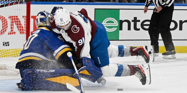 Colorado Avalanche center Nazem Kadri (91) crashes into St. Louis Blues goaltender Jordan Binnington (50) in the first period at the Enterprise Center during Game 3 of the second round of the NHL playoffs May 21, 2022.