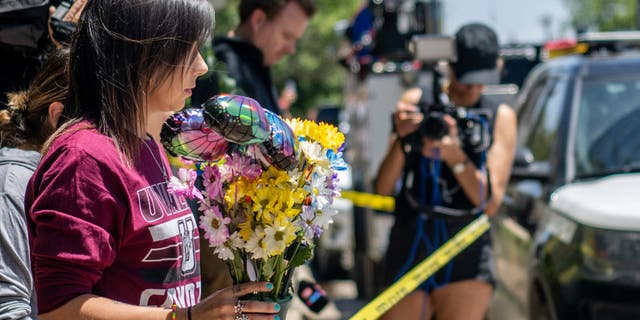 Community member Amanda Welch brings flowers to lay at Robb Elementary School.