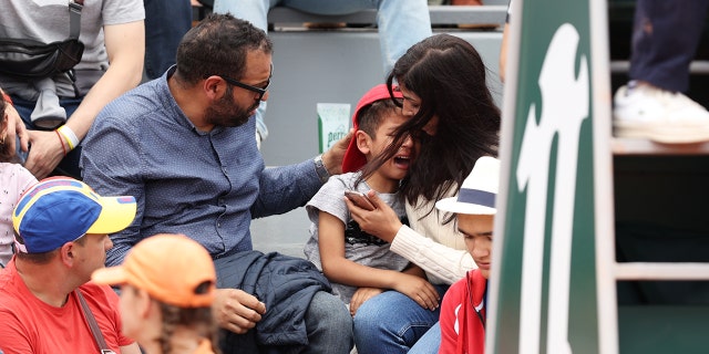 Parents comfort their child during the French Open at Roland Garros on May 26, 2022.