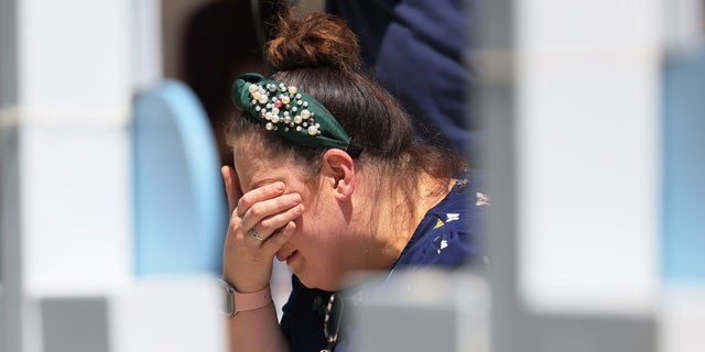 A mourners cries as she visits a memorial for a victim of Tuesday's mass shooting at an elementary school, in City of Uvalde Town Square on May 26, 2022, in Uvalde, Texas.