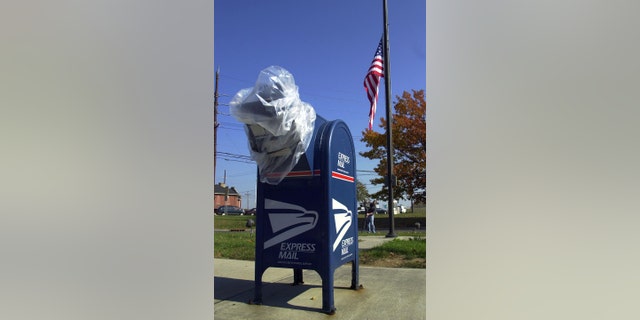 A mailbox is covered in plastic wrap when a U.S. flag flew in honor of half the staff at Washington Post Office who died in anthrax on October 24, 2001, in Hamilton, NJ. 